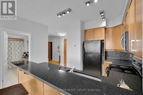 Ottawa condo for rent - A modern kitchen with a black granite countertop and wooden cabinets.