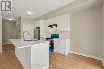 Ottawa townhouse for rent - A kitchen with white cabinets and a white island.
