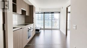 Toronto (Waterfront Communities) condo for rent - A modern kitchen with wooden cabinets and a large window.