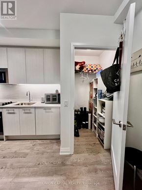 Toronto (East End-Danforth) condo for rent - A kitchen with white cabinets and a white fridge.