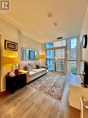 Toronto (East End-Danforth) condo for rent - A living room with a couch, a coffee table, and a rug.