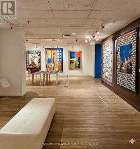 Toronto (Bay Street Corridor) condo for rent - A gallery with paintings on the wall and a bench in the middle.