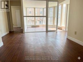 Toronto (Bay Street Corridor) condo for rent - A room with wooden floors and a view of a building outside the window.