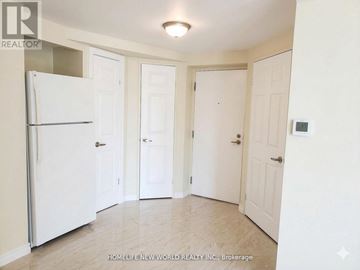 Toronto (Bay Street Corridor) condo for rent - A white refrigerator is in the corner of a kitchen with three doors.