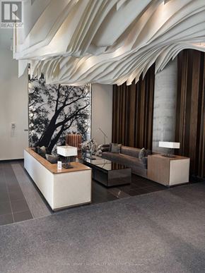 Toronto (High Park North) condo for rent - A modern living room with a large window and a tree outside.