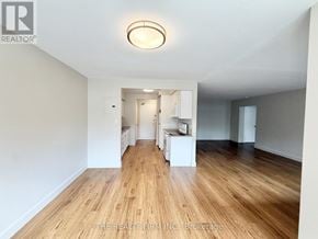 London South (South F) condo for rent - A spacious room with wooden flooring and white walls.