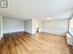 London South (South F) condo for rent - A spacious room with wooden flooring and white walls.