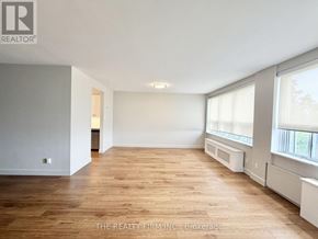 London South (South F) condo for rent - A spacious room with wooden flooring and white walls.
