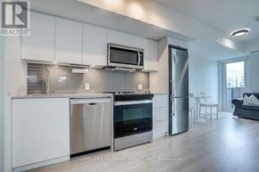 Toronto (Clanton Park) condo for rent - A modern kitchen with stainless steel appliances and white cabinets.