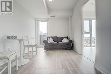Toronto (Clanton Park) condo for rent - A living room with a grey couch and a white table.