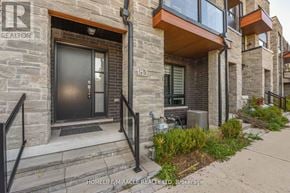 Vaughan (Vellore Village) townhouse for rent - A stone building with a black door and a window with a sign that says "REALTOR".
