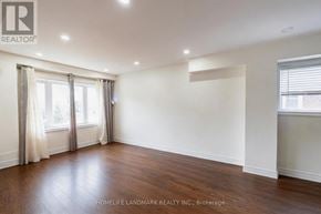 Toronto (Dorset Park) apartment for rent - A spacious room with wooden floors and white walls.