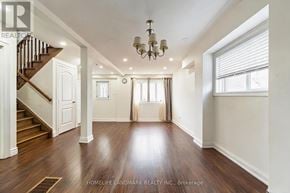 Toronto (Dorset Park) apartment for rent - A spacious room with wooden floors and a staircase.