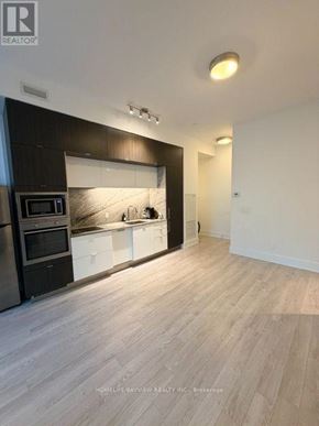 Toronto (Waterfront Communities) condo for rent - A modern kitchen with a black and white color scheme.