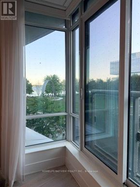 Toronto (Waterfront Communities) condo for rent - A window with a view of a park and buildings outside.