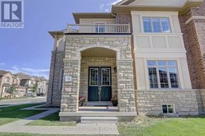 Oakville (Jm Joshua Meadows) apartment for rent - A house with a stone archway entrance and a balcony above it.