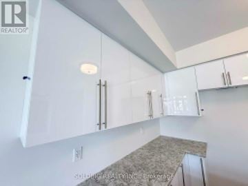 Brantford townhouse for rent - A kitchen with white cabinets and a granite countertop.