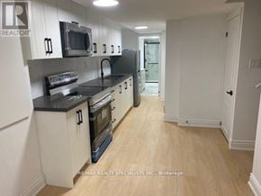 Mississauga (East Credit) apartment for rent - A kitchen with white cabinets and black countertops.