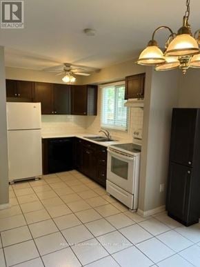 Burlington (Roseland) townhouse for rent - A kitchen with white appliances and brown cabinets.