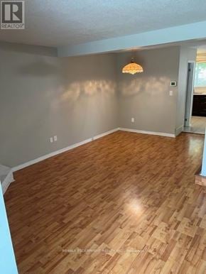 Burlington (Roseland) townhouse for rent - A room with wooden flooring and a light hanging from the ceiling.