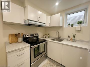 Cambridge apartment for rent - A kitchen with white cabinets and a black stove top.