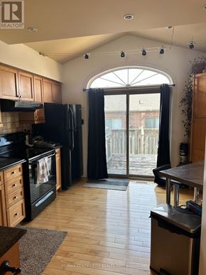 London North (North B) townhouse for rent - A kitchen with wooden cabinets and black appliances.