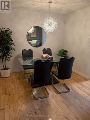 London North (North B) townhouse for rent - A chair with a green and white pillow is in the middle of a room with wooden floors and white walls.