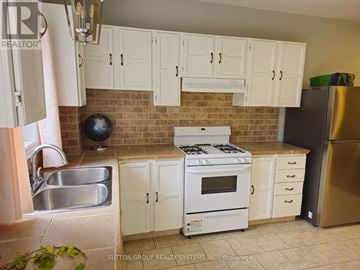 Brampton (Bram West) apartment for rent - A kitchen with white cabinets and a brick backsplash.