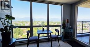 Vancouver apartment for rent - A room with a table and chairs in front of a large window with a view of the mountains.