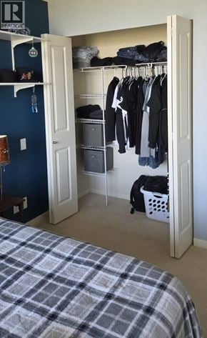 Vancouver apartment for rent - A bedroom with a bed and a closet with clothes hanging.