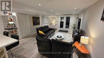 Newmarket (Bristol-London) apartment for rent - A modern living room with a black couch and a white coffee table.