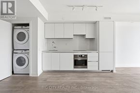 Toronto (Thorncliffe Park) condo for rent - A white kitchen with a washer and dryer in the corner.