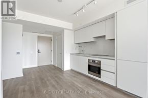 Toronto (Thorncliffe Park) condo for rent - A white kitchen with a stove top oven and a refrigerator.