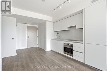 Toronto (Thorncliffe Park) condo for rent - A white kitchen with a stove top oven and a refrigerator.