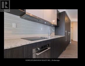 Toronto (Banbury-Don Mills) condo for rent - A modern kitchen with dark wood cabinets and stainless steel appliances.
