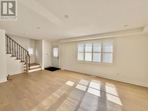Toronto (Clairlea-Birchmount) apartment for rent - A spacious room with wooden flooring and a staircase on the left side.