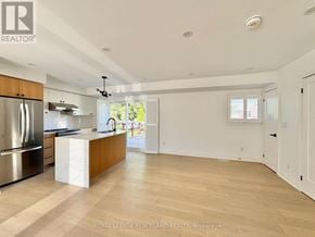 Toronto (Clairlea-Birchmount) apartment for rent - A spacious kitchen with wooden floors and a stainless steel refrigerator.