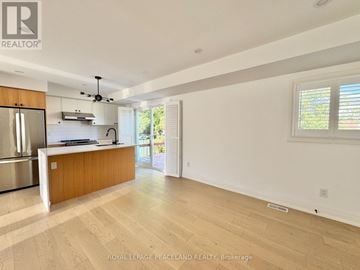 Toronto (Clairlea-Birchmount) apartment for rent - A spacious kitchen with wooden cabinets and a stainless steel refrigerator.