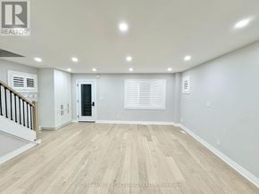 Toronto (Briar Hill-Belgravia) apartment for rent - A spacious room with wooden flooring and white walls.