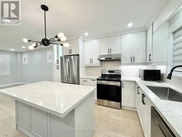 Toronto (Briar Hill-Belgravia) apartment for rent - A modern kitchen with white cabinets and a marble island.
