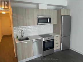 Toronto (Bay Street Corridor) condo for rent - A modern kitchen with stainless steel appliances and wooden cabinets.