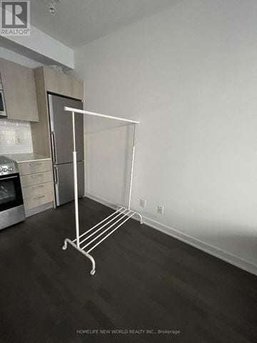 Toronto (Bay Street Corridor) condo for rent - A white metal rack stands in a kitchen with a microwave and oven.