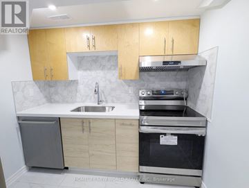 Toronto (Greenwood-Coxwell) apartment for rent - A kitchen with wooden cabinets and a stainless steel dishwasher.