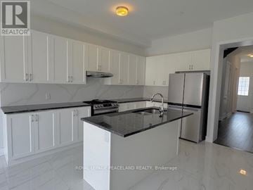 Aurora apartment for rent - A kitchen with white cabinets and a black countertop.