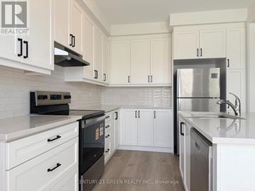 Milton (Bw Bowes) townhouse for rent - A kitchen with white cabinets and a black fridge.