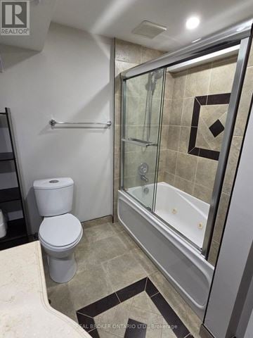 Barrie (Letitia Heights) apartment for rent - A bathroom with a toilet, a glass shower stall, and a tiled floor.