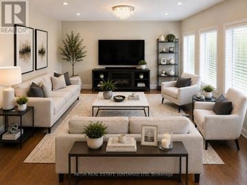 London North (North H) apartment for rent - A well-lit living room with a white sofa set, a black television, and a coffee table with a book and a candle on it.