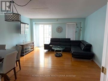 Ottawa townhouse for rent - A living room with a black couch and a glass coffee table.
