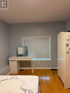 Ottawa townhouse for rent - A bedroom with a bed, desk, and a refrigerator.