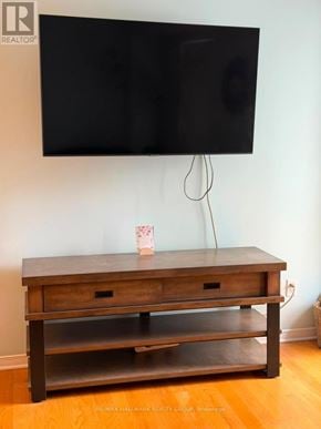 Ottawa townhouse for rent - A black TV is mounted on a white wall above a wooden tv stand.